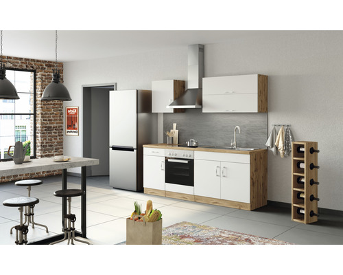 Moderní kuchyně s vestavěnými spotřebiči, jídelním stolem a barovými stoličkami ve světlé místnosti.