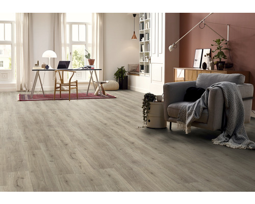 Světlý obývací pokoj s designovou podlahou s dřevěným vzhledem, psacím stolem a křeslem.