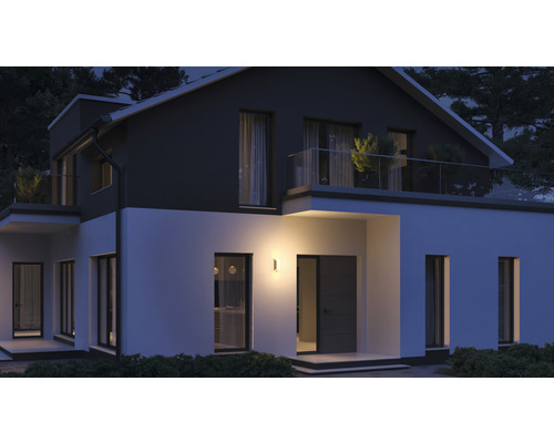 Osvětlený obytný dům se zahradou v noci