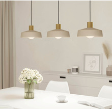 Tři závěsné lampy nad jídelním stolem ve světlé místnosti.