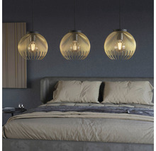 Ložnice se třemi kulatými kovovými závěsnými svítidly nad postelí