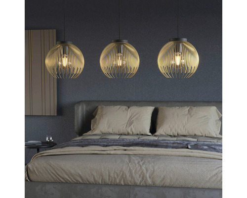 Ložnice se třemi kulatými kovovými závěsnými svítidly nad postelí
