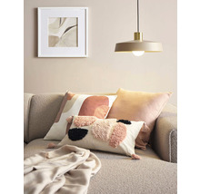 Dekorace obývacího pokoje s polštáři, dekou, lampou a zarámovaným obrázkem