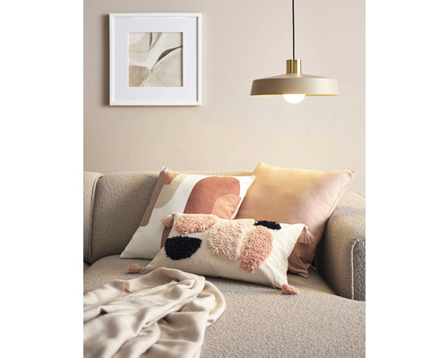 Dekorace obývacího pokoje s polštáři, dekou, lampou a zarámovaným obrázkem