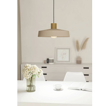 Béžová závěsná lampa nad jídelním stolem ve světlé místnosti.