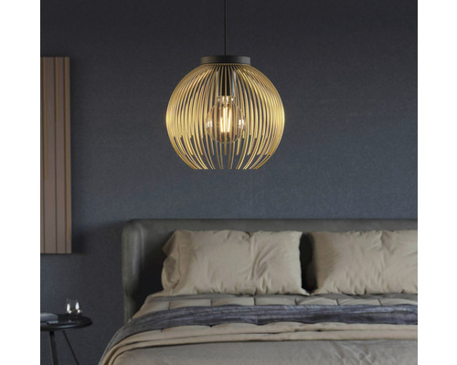 Závěsná lampa s kulovitým stínidlem z kovových tyčí nad postelí