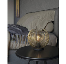 Dekorativní stolní lampa s kulovitým drátěným stínidlem na nočním stolku