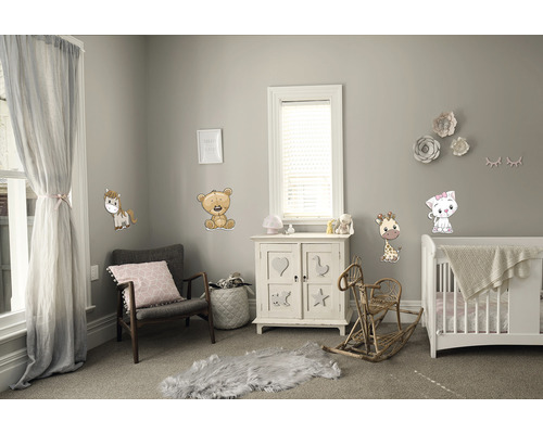 Dětský pokoj s nábytkem a nástěnnými samolepkami se zvířecími motivy.