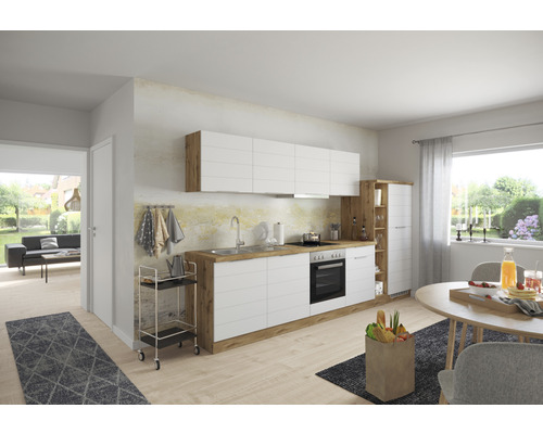 Světlá kuchyň s bílými čely a dřevěnými prvky, jídelní kout se stolem a židlemi.