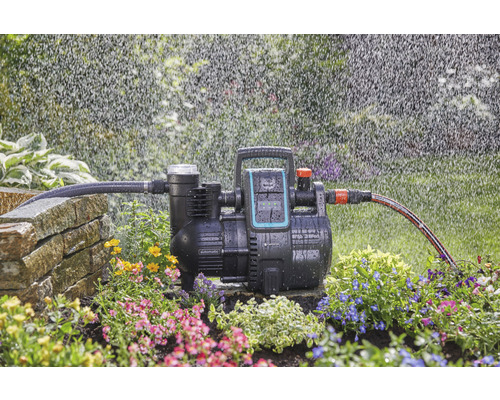 Automatický domácí vodní systém Gardena v provozu se zavlažováním na zahradě.