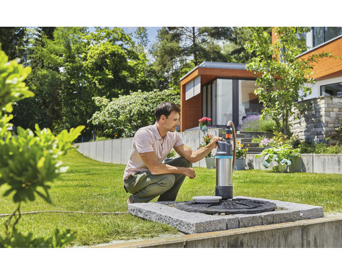 Muž obsluhuje zahradní čerpadlo Gardena na zahradě