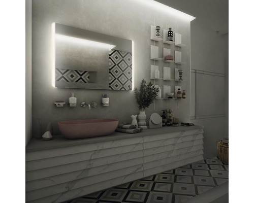 Moderní koupelna s osvětleným zrcadlem, umyvadlem, úložnými prostory a geometrickými obklady