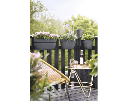 Balkonová scéna s truhlíky, stolem a židlí na dřevěné podlaze