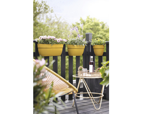 Scéna s truhlíky na zábradlí, odkládacím stolem s nápoji a židlí.