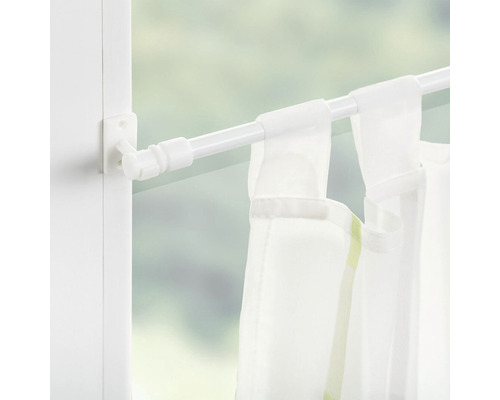 Bílá záclonová tyč s držákem a záclonou v okně