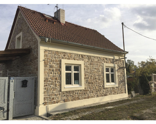 Fasáda domu s kamenným obkladem a sedlovou střechou