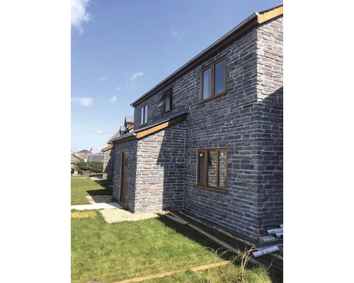 Fasáda domu s kamenným obkladem a okny