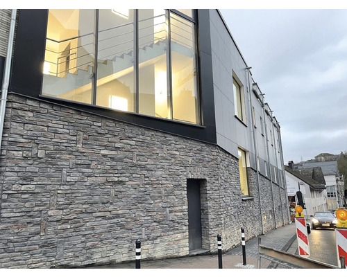 Budova s fasádou imitující kámen a velkými okny