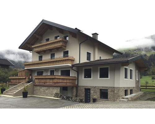 Velký dům s balkony a kamennou fasádou.