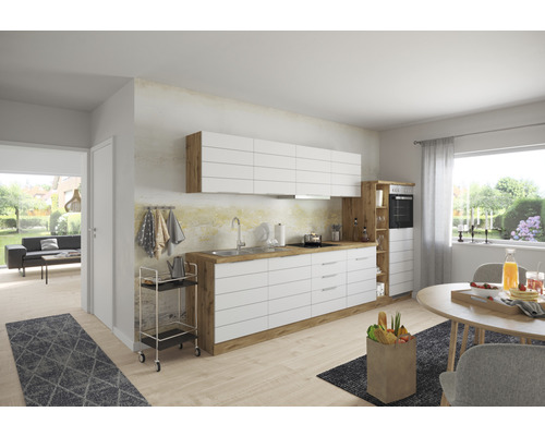 Světlá kuchyně s bílými skříňkami a dřevěnou pracovní deskou, jídelní stůl a obývací prostor v pozadí