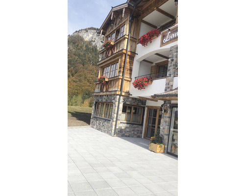 Vnější pohled na vícepatrovou budovu s dřevěnou fasádou a kamennými zdmi