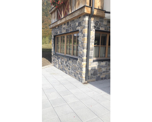 Fasáda domu s kamennou zdí a dlažebními kostkami