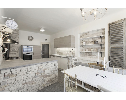 Pohled na kuchyň s jídelním stolem, kuchyňskou linkou a policemi