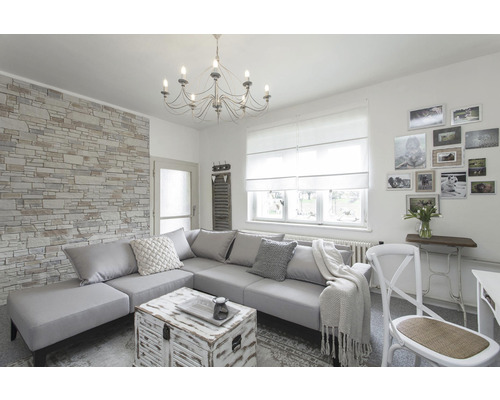 Obývací pokoj s rohovou pohovkou, kamennou tapetou a lustrem