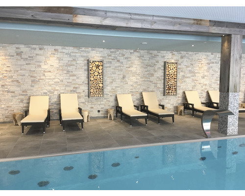 Plavecký bazén s lehátky a dekorativními dřevěnými prvky na zdi