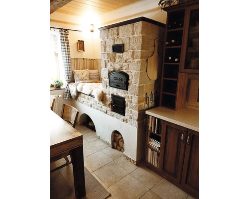 Interiér s kamenným krbem, lavicí u okna, dřevěným stolem a kuchyňskou skříňkou