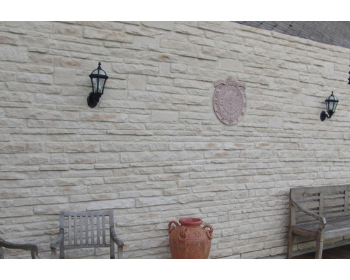 Nástěnná dekorace s obkladovými panely, nástěnnými svítidly a dekoracemi pro venkovní použití.