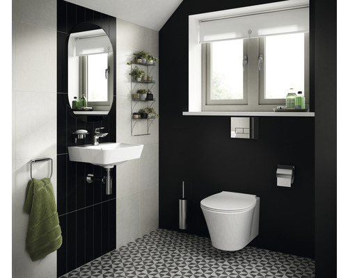 Světlá koupelna s umyvadlem, zrcadlem, toaletou a geometrickým vzorem podlahy