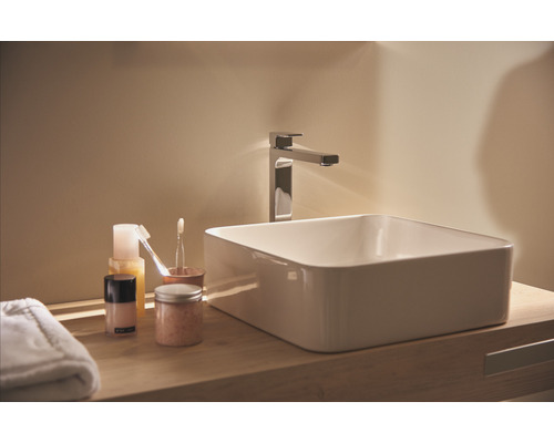 Umyvadlo v koupelně s vodovodní baterií a kosmetickými produkty na dřevěné polici