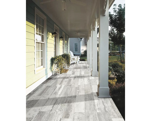 Veranda s dřevěnou podlahou, sloupy a posezením