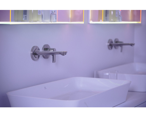 Nástěnná nerezová baterie nad bílým umyvadlem na desku