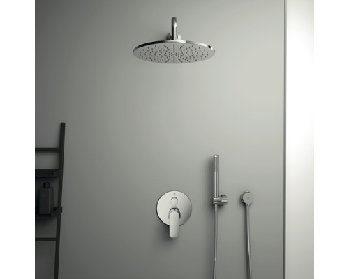 Sprchová hlavice s armaturou a ruční sprchou na šedé zdi