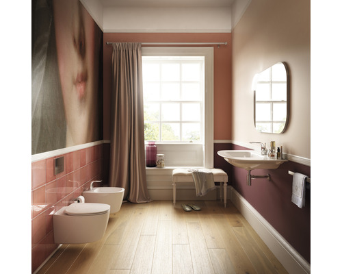 Koupelna s toaletou, bidetem, umyvadlem, zrcadlem a oknem pro světlou atmosféru.