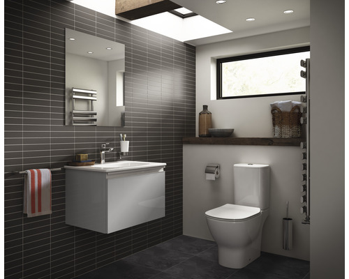 Moderní koupelna s toaletou, skříňkou pod umyvadlo, zrcadlem a ohřívačem ručníků.