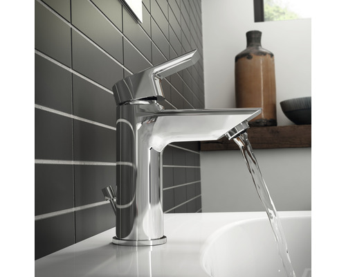 Lesklá kovová vodovodní baterie v koupelně s tekoucí vodou