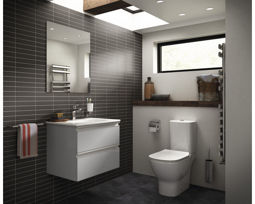 Moderní koupelna s umyvadlovou skříňkou, zrcadlem, toaletou a topným tělesem na ručníky.