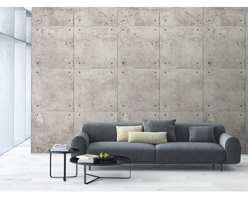 Obývací pokoj s šedou pohovkou a nástěnnými panely s betonovým vzhledem