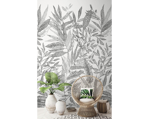 Obývací pokoj s botanickou tapetou, proutěným křeslem a pokojovou rostlinou