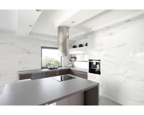 Světlá kuchyně s varným ostrůvkem, digestoří a obklady s mramorovým vzhledem