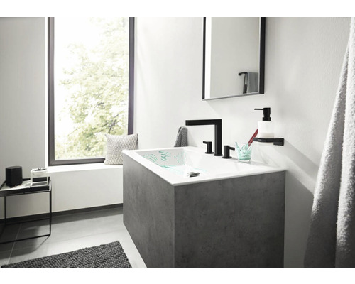 Moderní koupelna s umyvadlem, vodovodní baterií, zrcadlem a oknem.