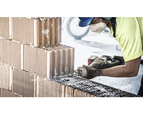 Zedník řeže cihlu pilou.