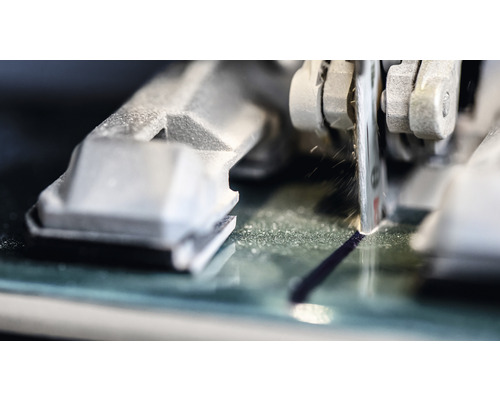 Detailní záběr řezačky skla řezající sklo