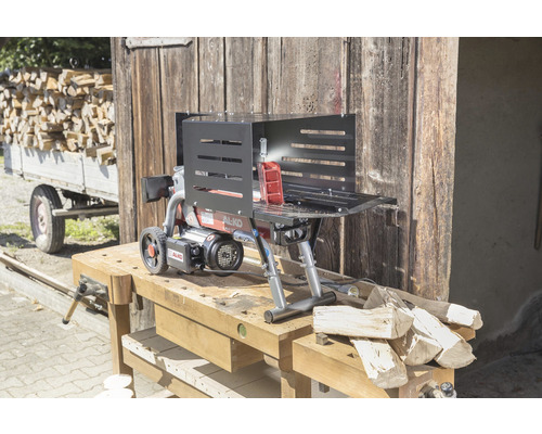 Štípačka na dřevo na pracovním stole před dřevěnou stěnou