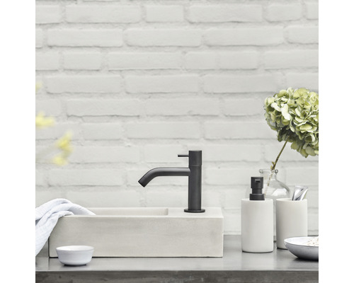 Moderní koupelna s umyvadlem, baterií a dekorativními předměty.