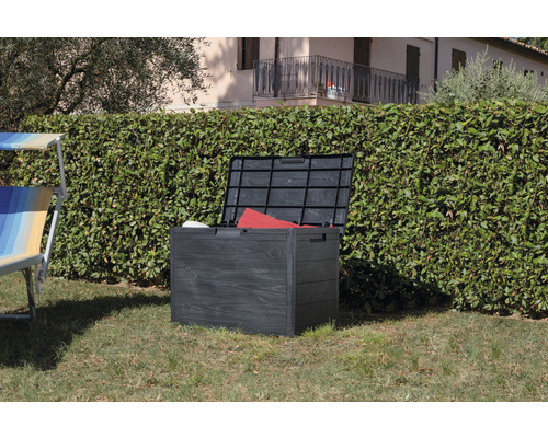 Otevřený zahradní box z plastu na trávníku před živým plotem.