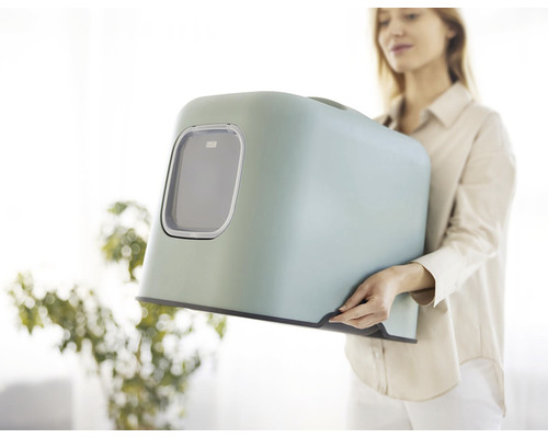 Žena drží kočičí toaletu s víkem a okénkem